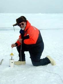 Terry Whitledge lowering a sampler through the pack ice.