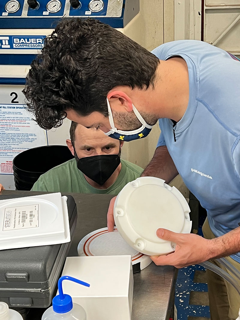 Co-chief scientist Erik Cordes and graduate student Luke McCartin set up the high-volume eDNA filter which, once attached to remotely operated vehicle <i>Global Explorer</i>, is able to filter approximately 50 liters of water through a specialized pump in real time, enabling scientists to sample the water column during a single dive.
