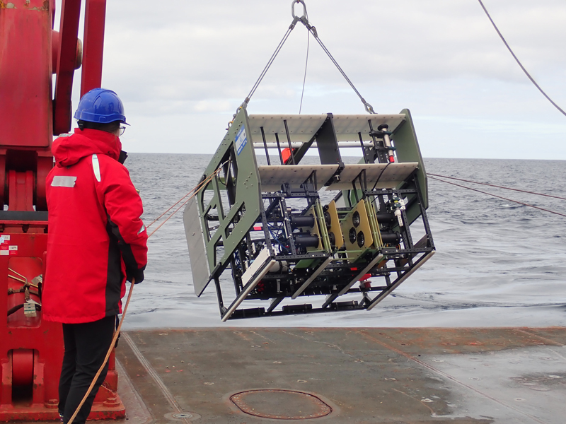 Grace Cawley helps deploy the In-Situ Ichthyoplankton Imaging System Deep-Focus Particle Imager (ISIIS-DPI) off the back of Research Vessel Sikuliaq.