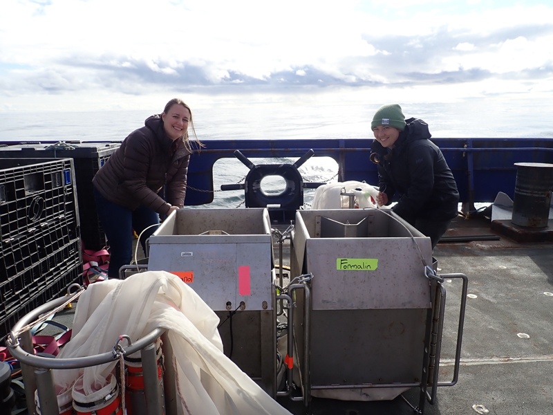Caitlin Smoot and Alex Poje (left to right) prepare the custom-built, tandem MultiNet system for deployment. The labels on the frame indicate the type of preservative that was to be used for the organisms collected and thus how and where they were to be analyzed.