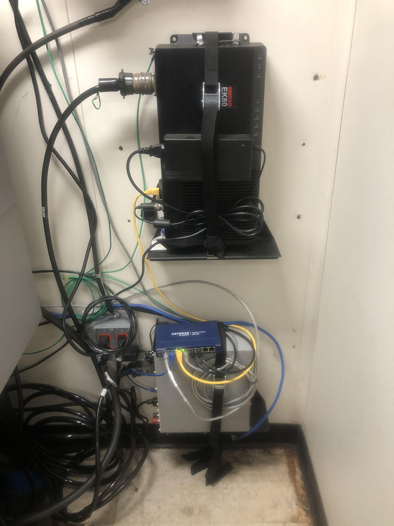 Figure 3: Image of the general purpose transceiver (GPT) (bottom, grey box) and the wide band transceiver (WBT) (top, black box) on NOAA Ship Okeanos Explorer. This WBT controls the 38 kilohertz frequency and was upgraded from a GPT in 2021.